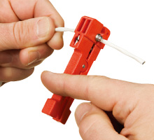 ケーブルをV型の溝に入れ、矢印の方向に回転させます